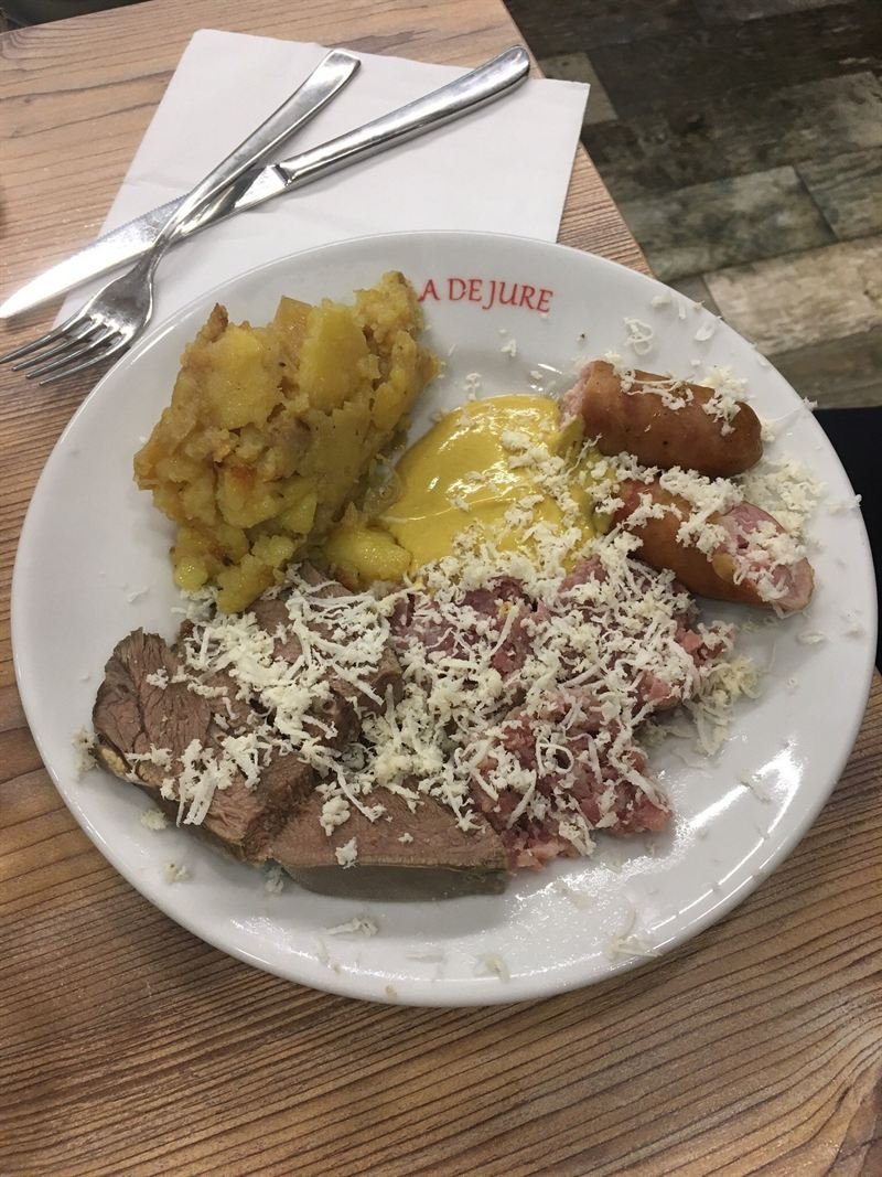 Caldaia triestina: carni di maiale bollite con senape, kren grattugiato e patate in tecia, nel piatto con la scritta La De Jure.