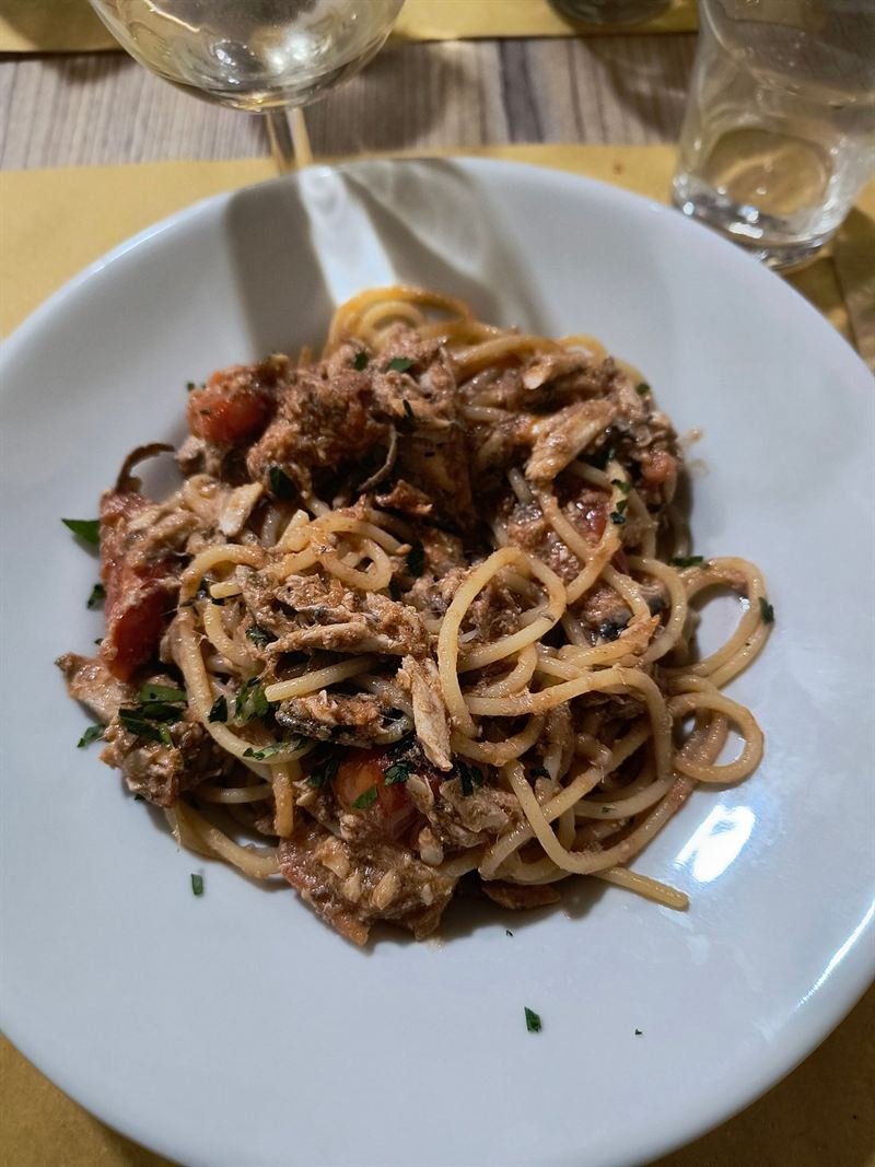 Spaghetti con sugo di pesce, pomodoro e prezzemolo, con un calice di bianco.